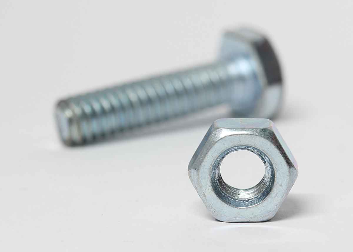 Nut and bolt close up on a white surface